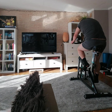 Frau genießt ein gelenkschonendes Indoor-Cycling-Training auf ihrem Wenoker Heimtrainer