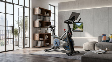 A budget-friendly Wenoker JC318 magnetic smart bike with an iPad mounted on the console displaying a virtual cycling route under $300
