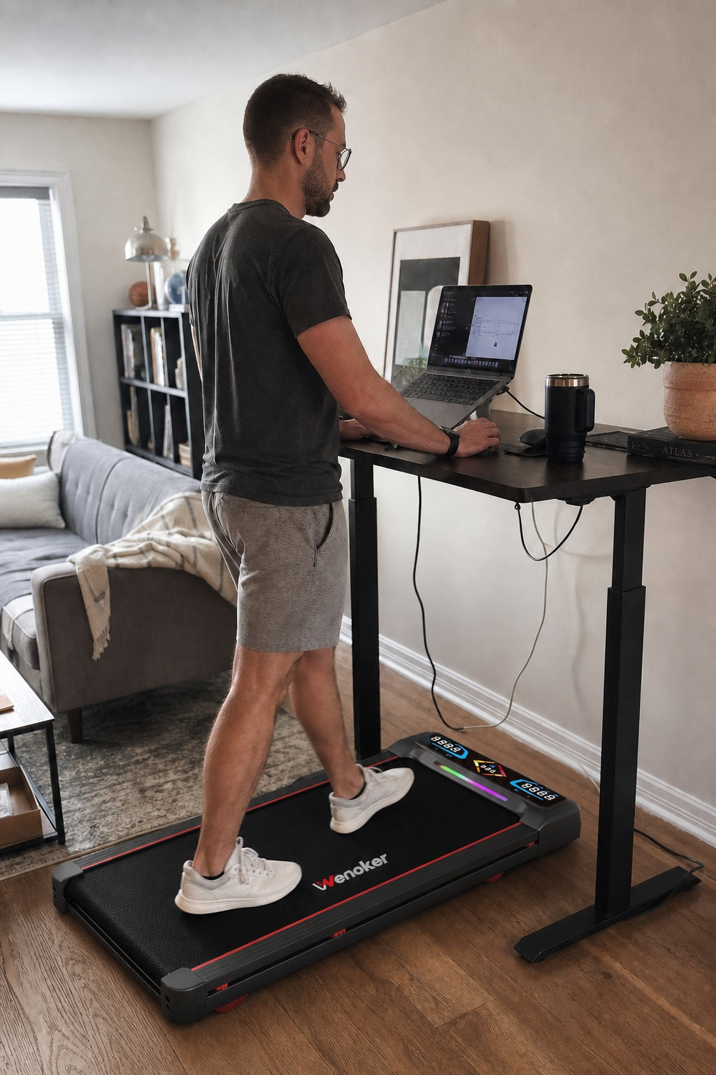 Man using a Wenoker A8 incline walking pad at a home office standing desk